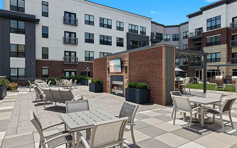 an outdoor patio with a tv and seating options