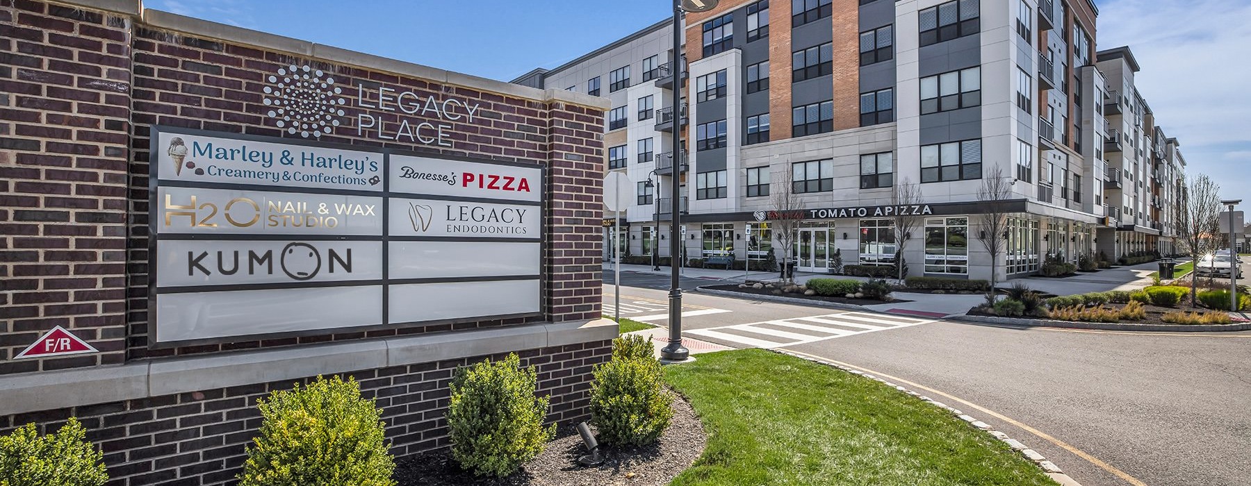 a plaza sign across the street from a building